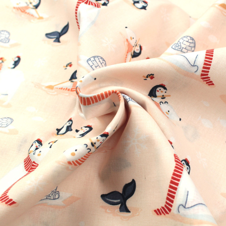 Tissu en coton rose saumon clair avec imprimé pingouins et ours.