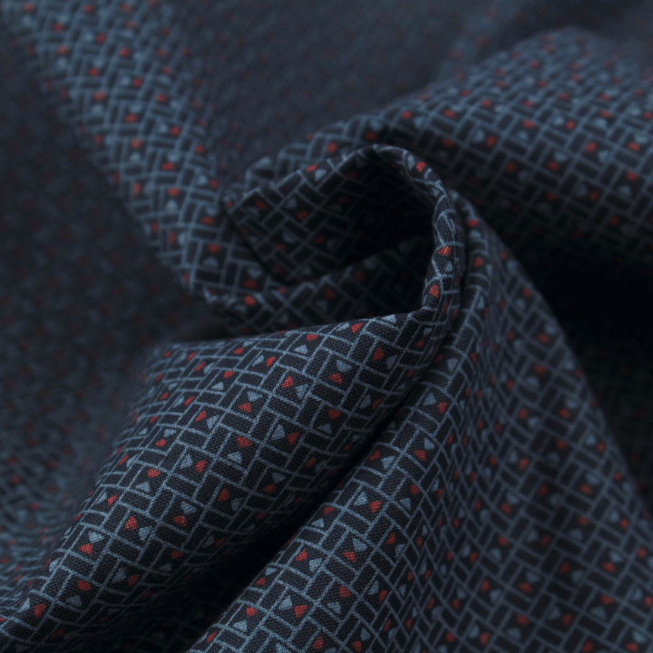 Tissu en coton bleu nuit à motif géométrique de petits triangles rouges et bleus