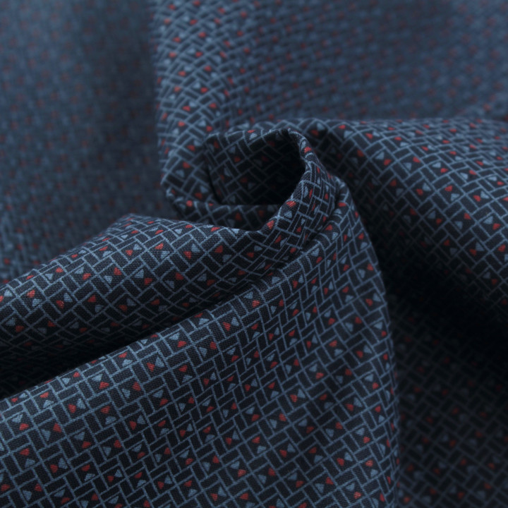 Tissu en coton bleu nuit à motif géométrique de petits triangles rouges et bleus