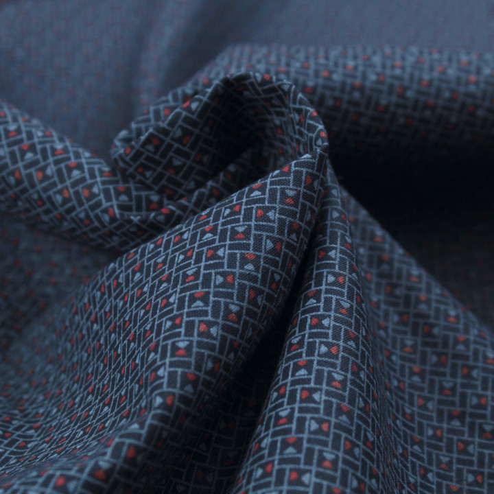 Tissu en coton bleu nuit à motif géométrique de petits triangles rouges et bleus