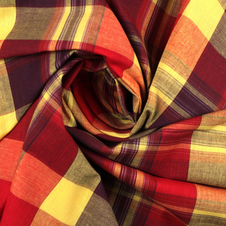 Tissu madras de couleur bordeaux, rouge, orange et jaune