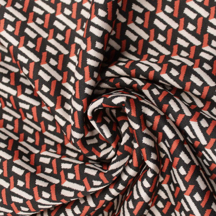 Tissu jersey noir motifs géométriques blancs et orange peu extensible